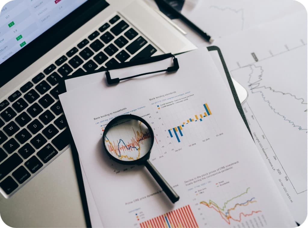 Loupe posee sur des documents financiers et des graphiques boursiers