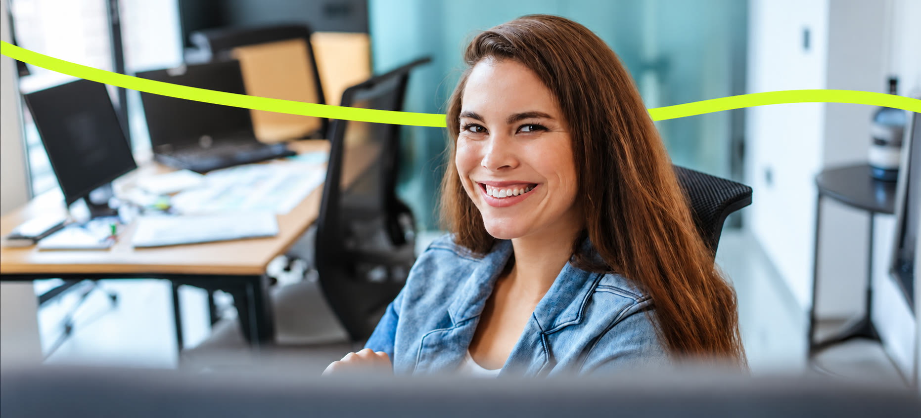Une bénévole souriante à son bureau, dans les locaux de l’association